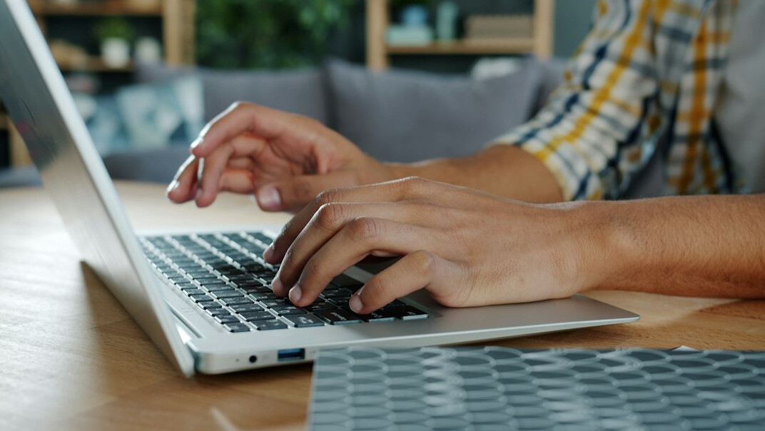 writer typing on laptop